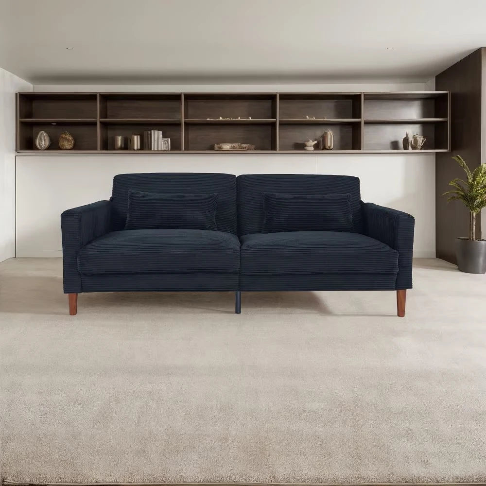 Blue sofa in a modern living room with a bookshelf in the background.