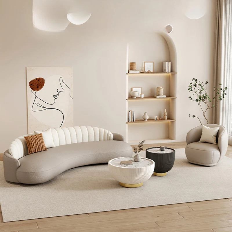 Modern living room with a curved gray sofa, armchair, and coffee table.