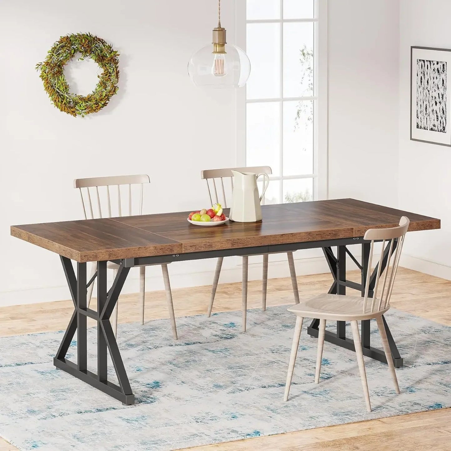 A rectangular, two-tone dining table with a distressed wood tabletop and a black metal trestle base, set in a room with chairs and decorative wall art.