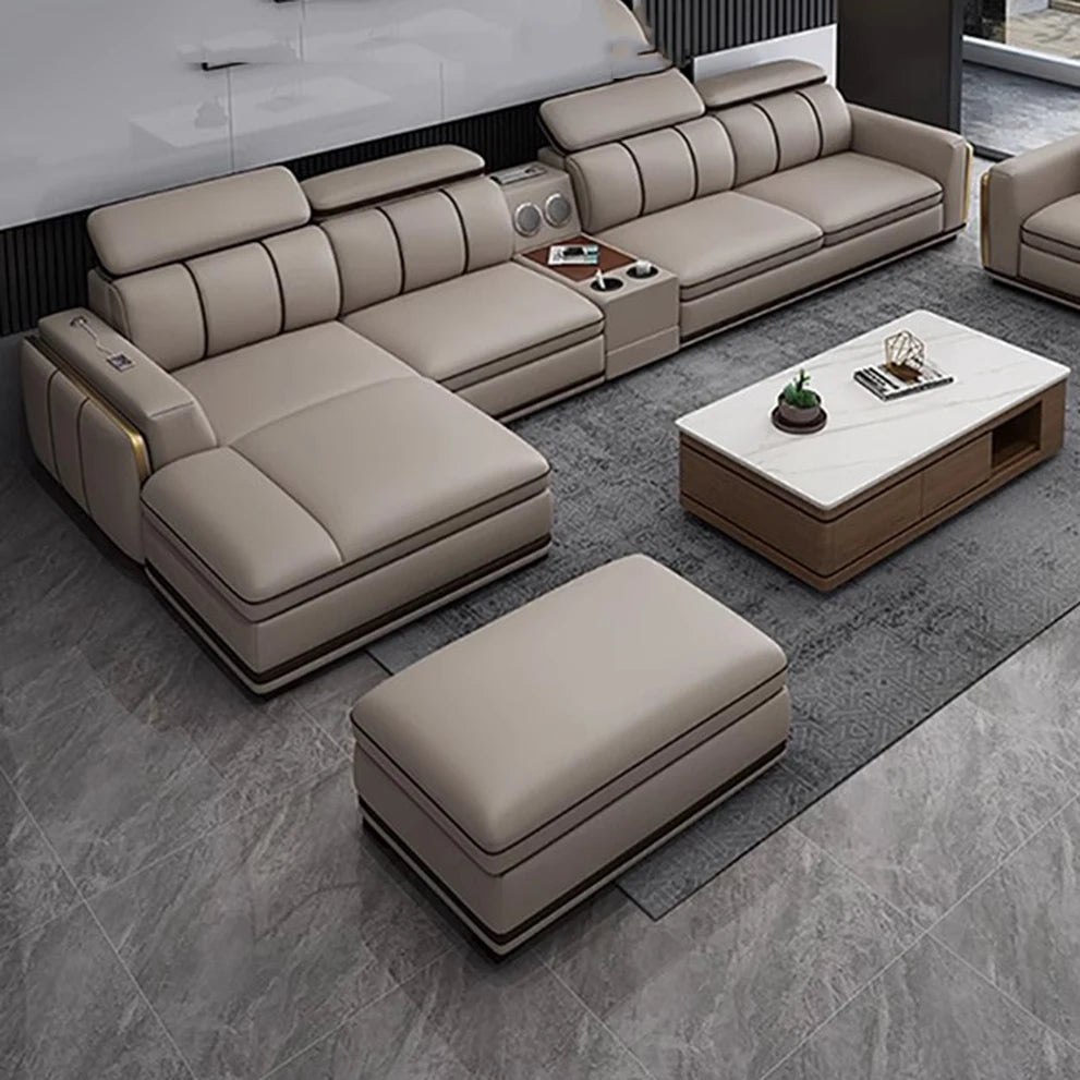 Beige sectional sofa with ottoman and coffee table in a modern living room setting.