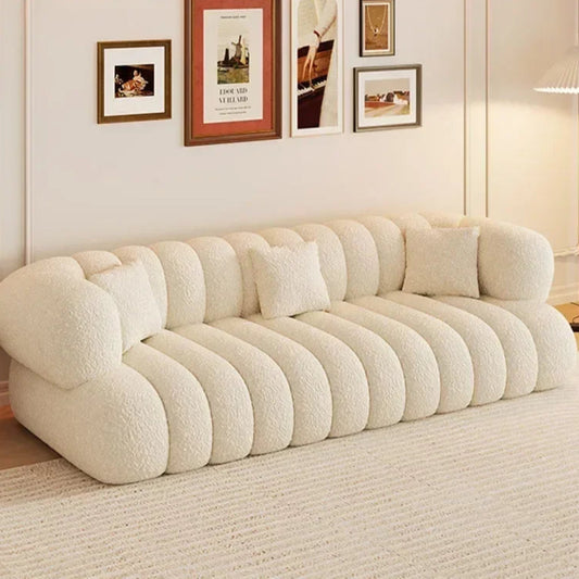 Beige sofa in a living room with framed pictures on the wall.