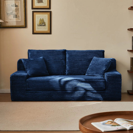 Blue textured sofa in a living room setting with framed pictures on the wall.