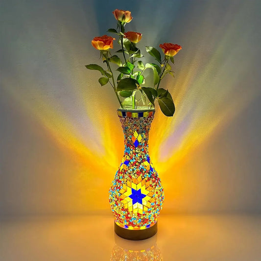 Colorful mosaic vase with flowers on a reflective surface