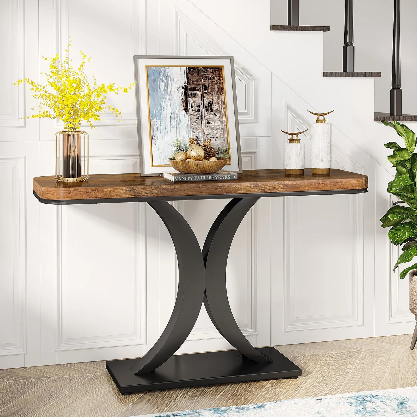 Console table with wooden top and black metal legs against a white paneled wall.