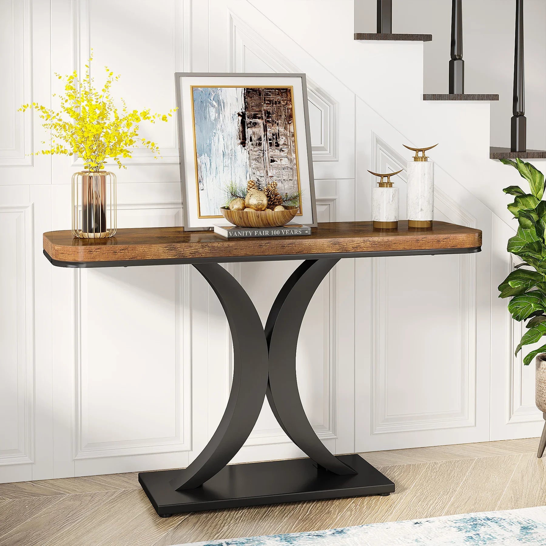 Console table with wooden top and black metal legs against a white paneled wall.