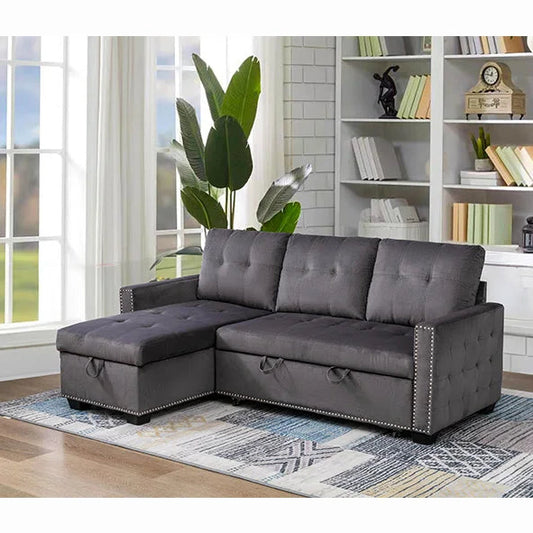 Gray sectional sofa in a living room with bookshelf and plants