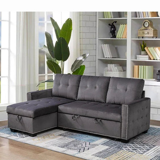 Gray sectional sofa in a living room with bookshelf and plants