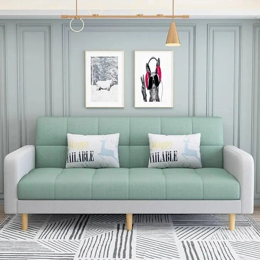 Light green sofa with white cushions in a room with gray walls and decorative elements.