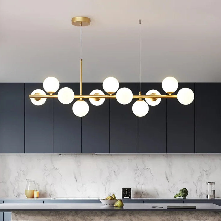 Modern kitchen with a gold pendant light fixture against a dark cabinet background.