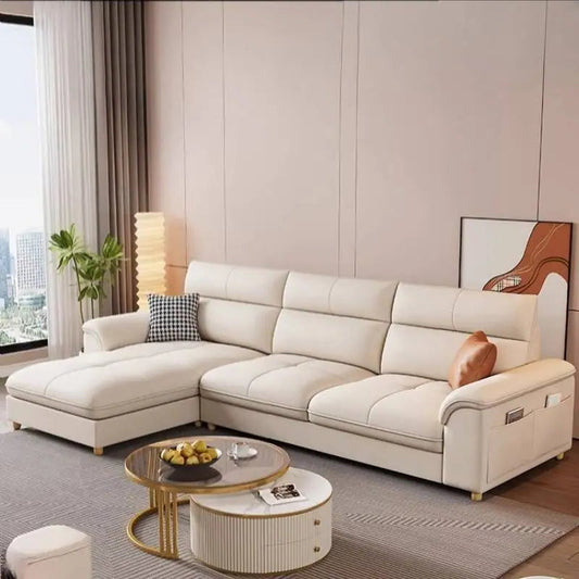Modern living room with a beige sectional sofa, coffee table, and decorative items.