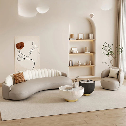 Modern living room with a curved gray sofa, armchair, and coffee table.