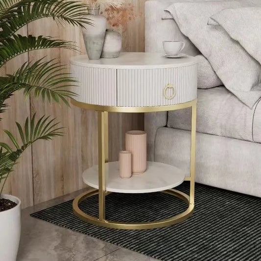 Modern side table with gold legs and white top in a living room setting.