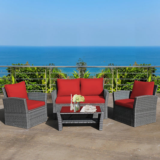 Outdoor furniture set with red cushions and a small table on a balcony with ocean view.