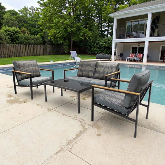 Outdoor patio furniture set by a pool with a house and trees in the background