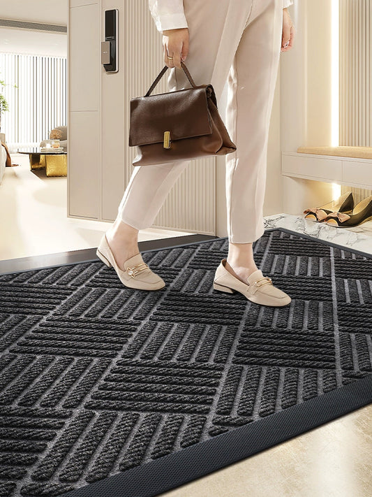 Person stepping onto a textured black doormat with a modern interior background
