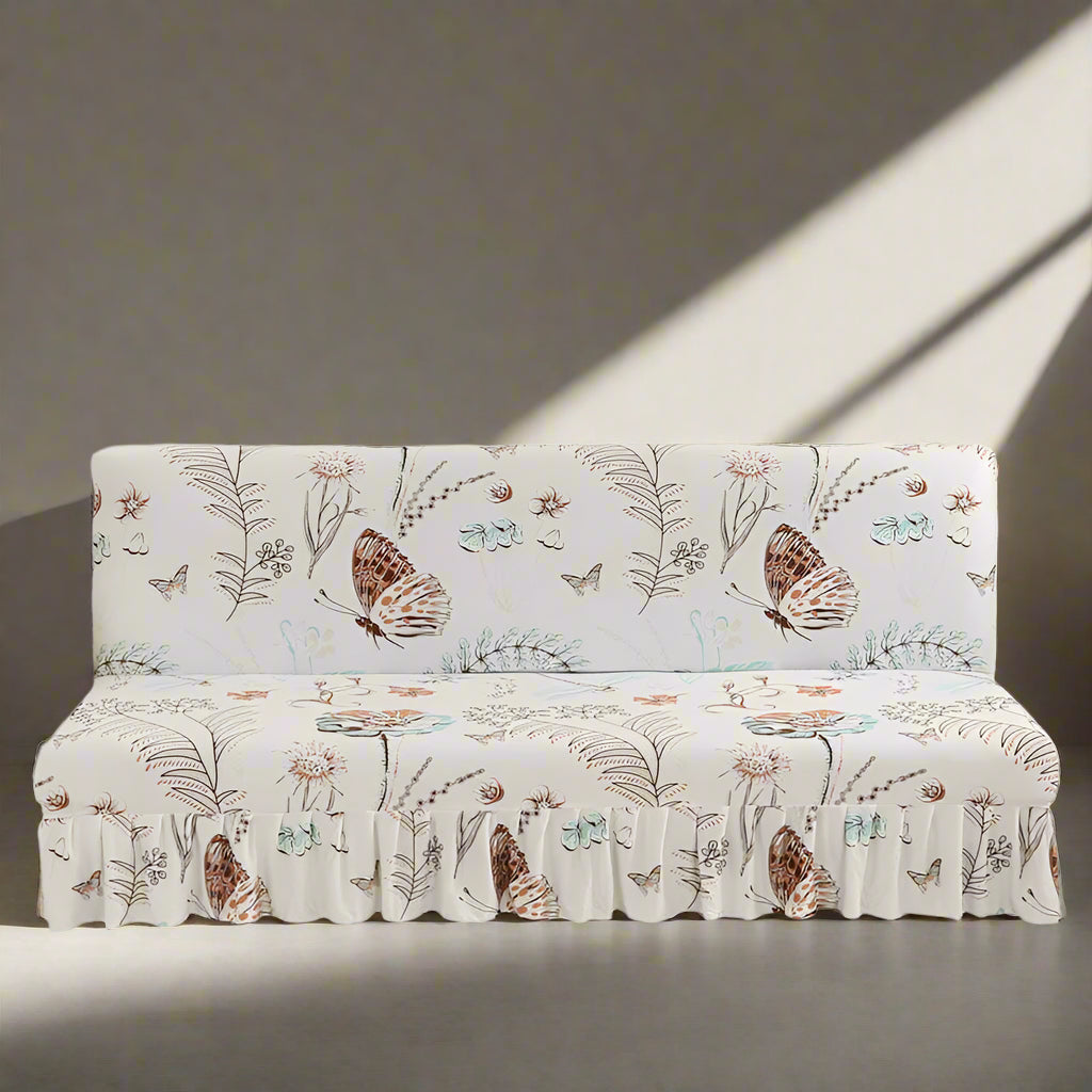 Sofa with a floral and butterfly patterned cover in a room with a pink wall.